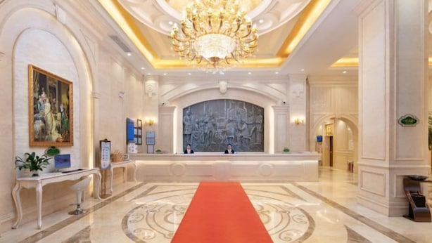 Eine prachtvolle Lobby mit Marmorboden, rotem Teppich und einer großen Chandelier.