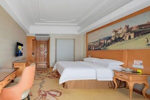 A hotel room with a bed, a desk, a chair, a television, and a painting of a castle on the wall. - Vienna Hotel (Longhui High-speed Railway Station) (Longhui)