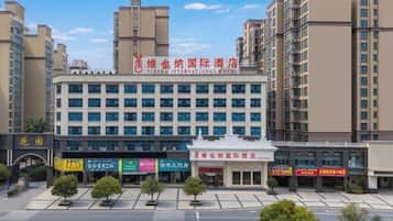 A hotel with a modern facade, multiple floors, and a prominent sign.