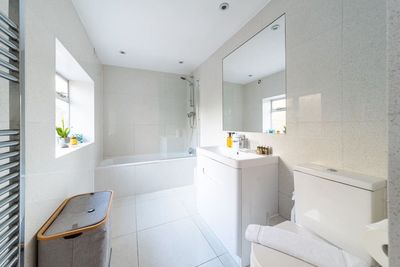A modern bathroom with a bathtub, shower, and a vanity with a mirror.