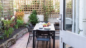 Eine Terrasse mit einem für das Frühstück gedeckten Tisch, einschließlich Obst und Gebäck.