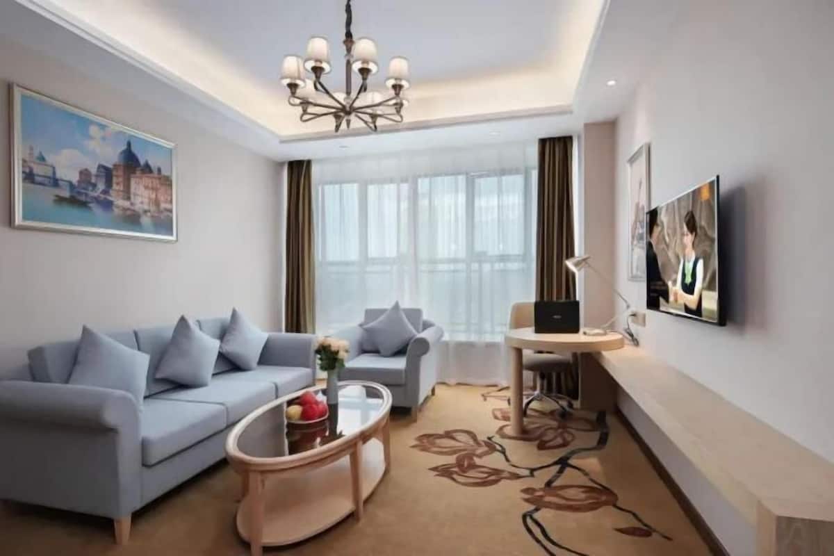 A modern living room with a sofa, coffee table, and a TV.