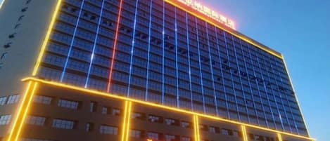 A multi-story hotel building with illuminated signage and a prominent entrance.