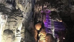 A cave interior with stalactites and a purple light. - Vienna International Hotel (Dushan) (Dushan)