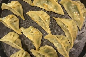 A pan with several dumplings cooking. - Yiru Hotel (Xinfeng) (Xinfeng)