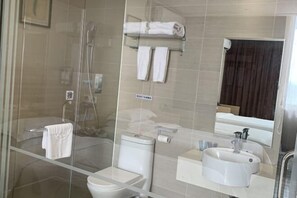 A modern bathroom with a glass shower enclosure, a toilet, a sink, and a towel rack. - Yiru Hotel (Xinfeng) (Xinfeng)