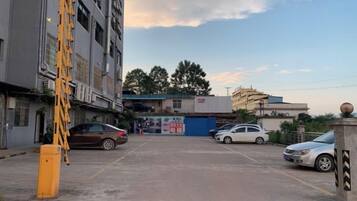 A parking lot with several cars, a yellow ladder, and buildings in the background.