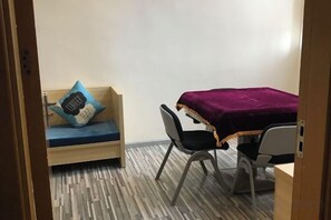 A small room with a bed, a chair, a desk, and a wall-mounted shelf. - Yiru Hotel (Xinfeng) (Xinfeng)