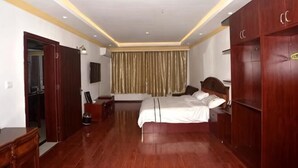 Un dormitorio con cama, armario de madera y espejo.