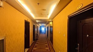 Pasillo de hotel con pisos alfombrados, puertas a ambos lados y un letrero que indica la habitación 601.