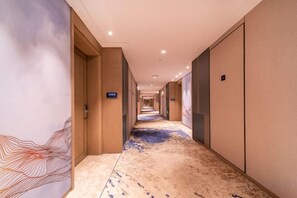 A hotel corridor with a carpeted floor, doors on both sides, and a number sign on the wall. - Fuqing Yonghong Hotspring Resort (Fuqing)