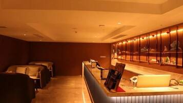 A hotel lobby with a reception desk, seating area, and a wall of framed pictures.