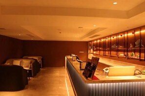 A hotel lobby with a reception desk, seating area, and a wall of framed pictures. - Fuqing Yonghong Hotspring Resort (Fuqing)