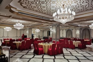 A banquet hall with round tables, red chairs, chandeliers, and a patterned floor. - Fuqing Yonghong Hotspring Resort (Fuqing)