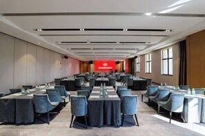 A conference room with tables and chairs arranged for meetings, a red banner with text, and large windows along one wall. - Fuqing Yonghong Hotspring Resort (Fuqing)