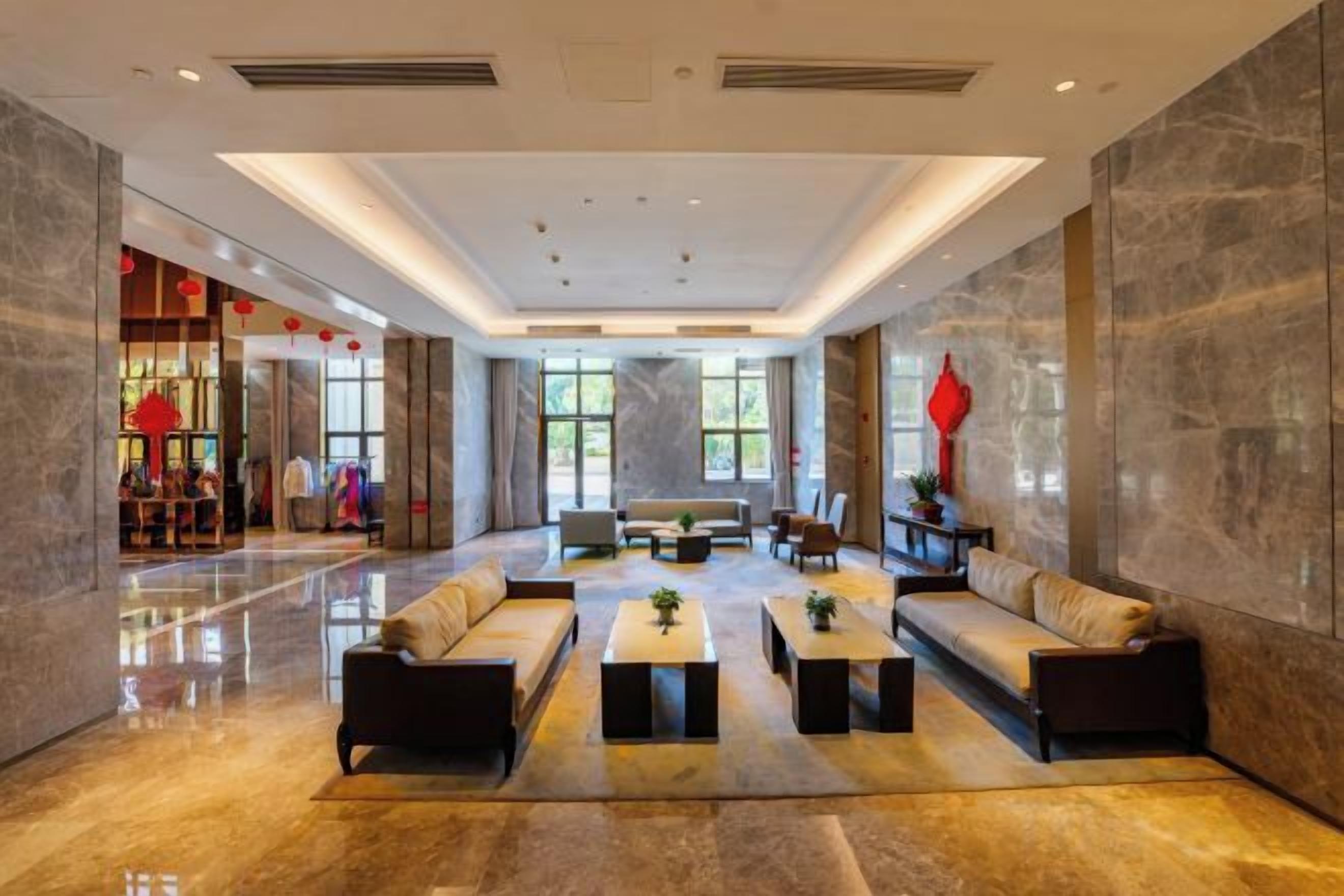 A spacious lobby with a seating area, a reception desk, and a view of the outdoors.