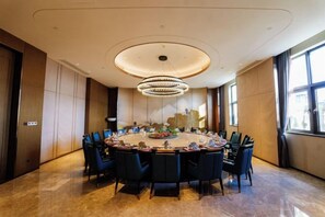 A conference room with a round table, chairs, and a chandelier. - Fuqing Yonghong Hotspring Resort (Fuqing)