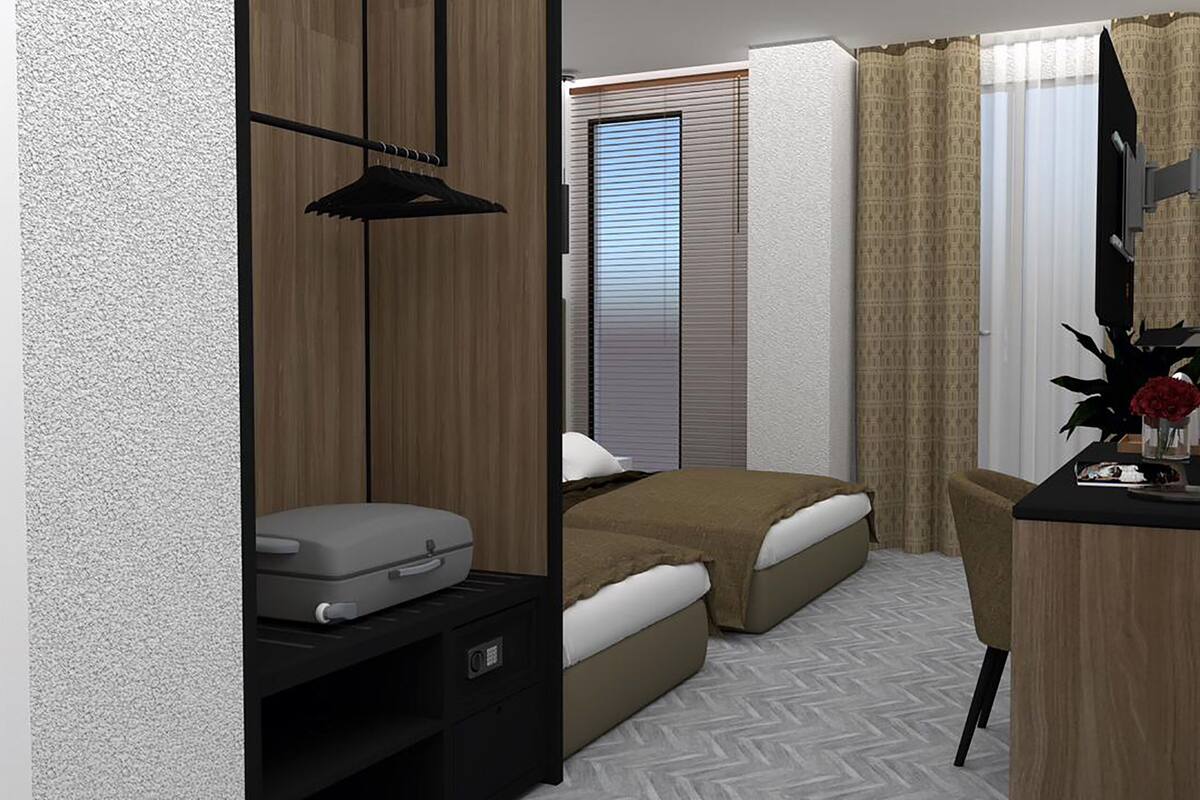Ein Schlafzimmer mit einem Bett, einem Schreibtisch, einem Stuhl, einem Fenster mit Jalousien und einem Vorhang.