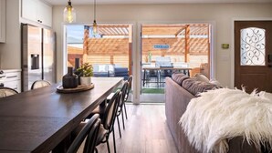 Una cocina moderna con una mesa de comedor de madera, sillas e iluminación colgante.