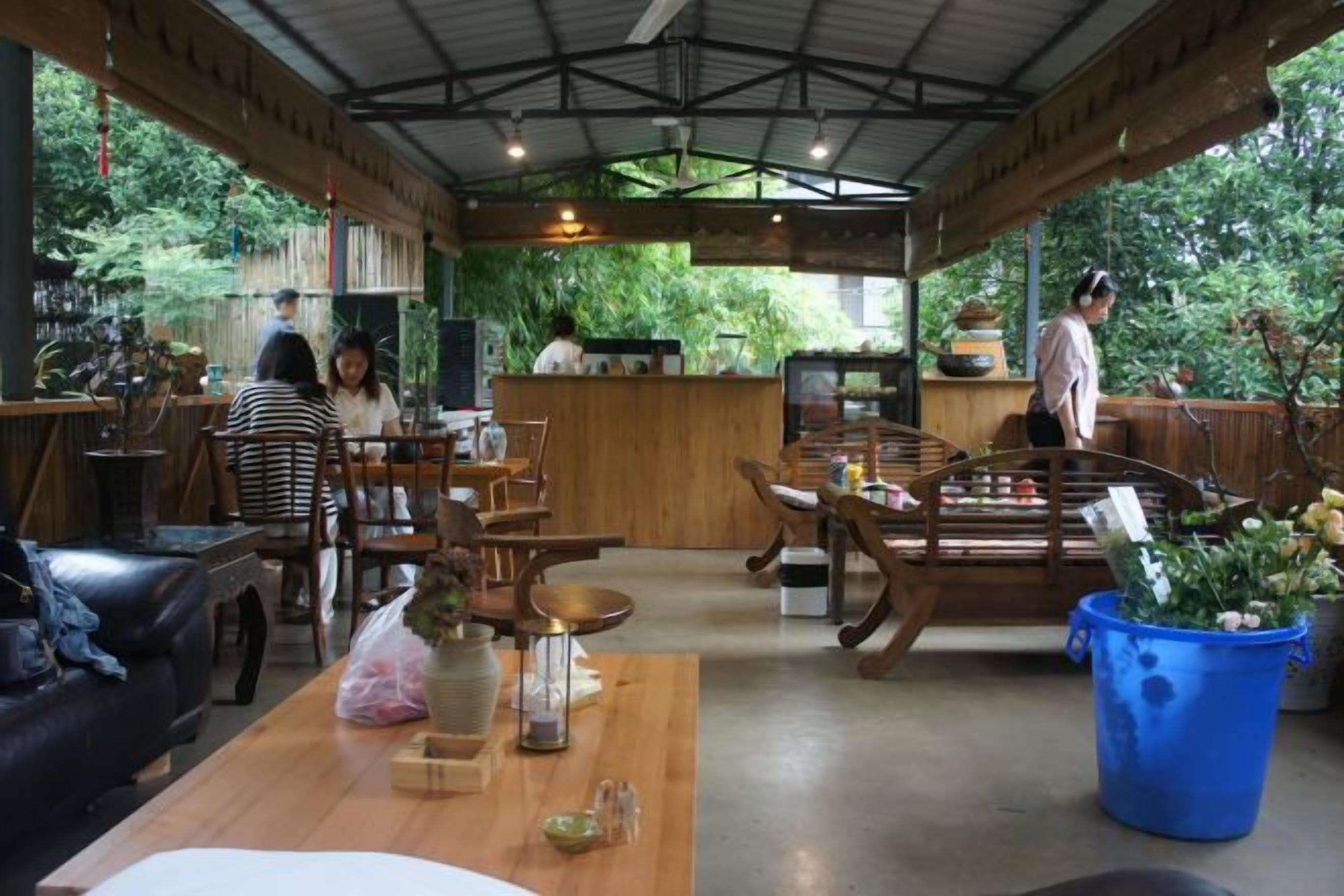 A restaurant with wooden furniture, a counter, and a view of greenery.