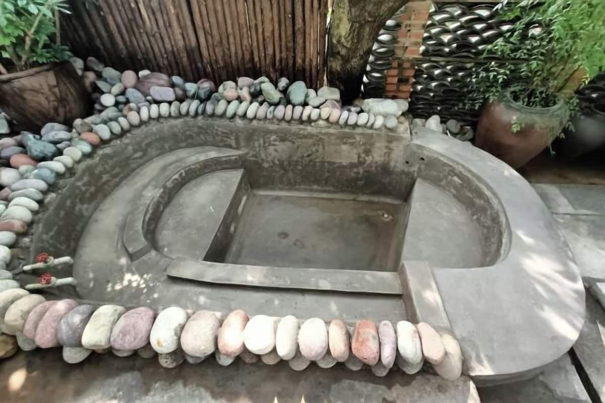A circular stone structure with a central basin, surrounded by a ring of stones.