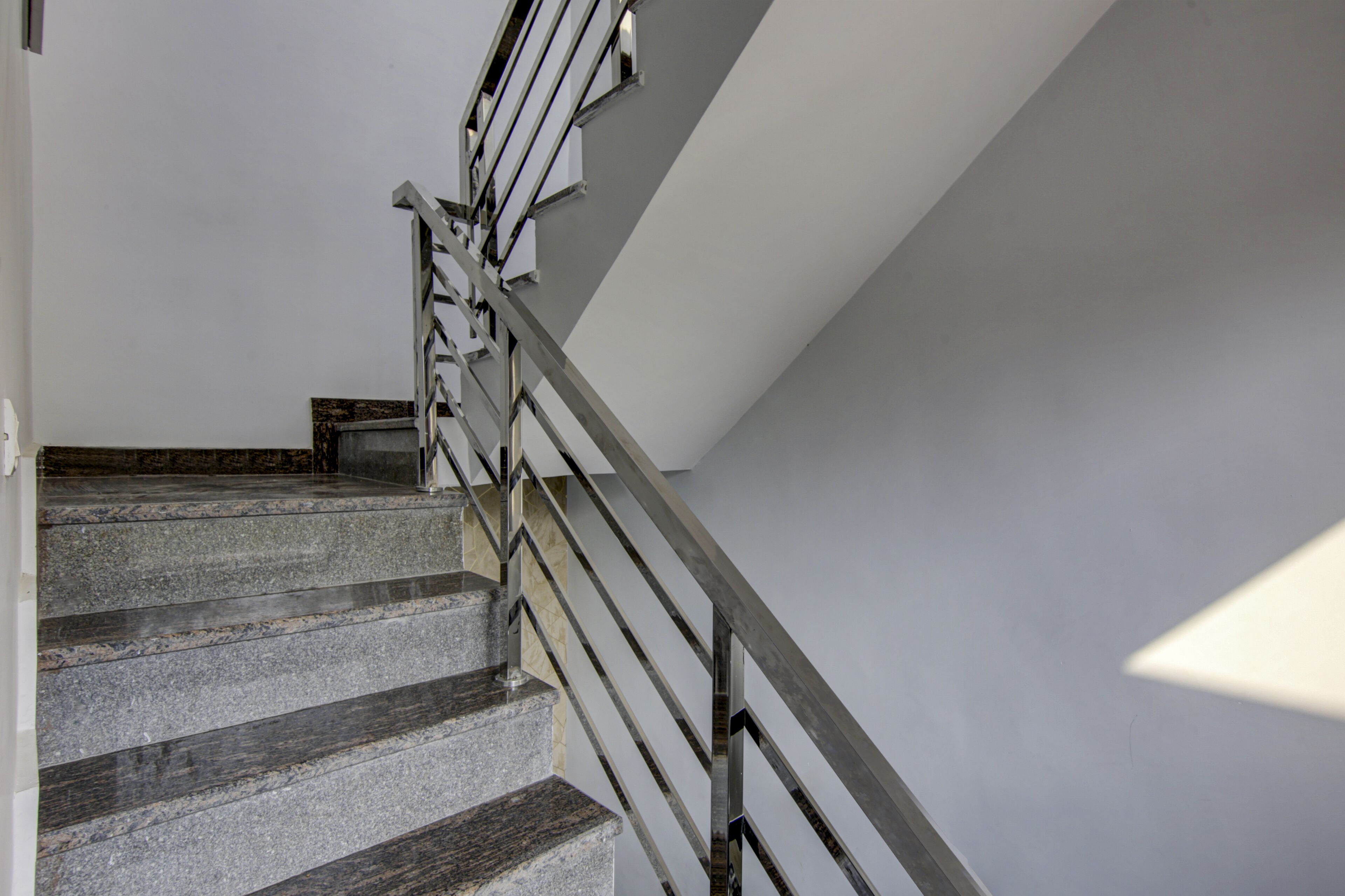 A staircase with a metal handrail and stone steps.