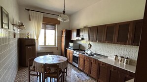 A kitchen with a dining table, cabinets, and a sink.
