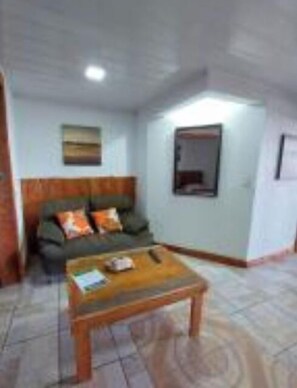 Relax in this cozy space with a sofa, coffee table, and window.