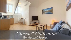 A modern living space with a kitchen, dining area, and a cozy seating area with a TV and lamp.