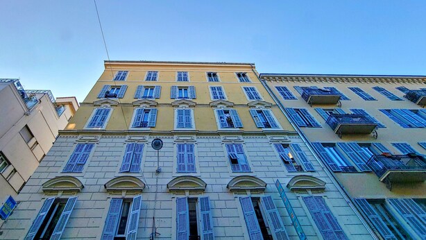 A multi-story building with a classical architectural style, featuring arched windows and balconies.