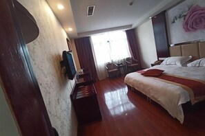 Ein Hotelzimmer mit Bett, Schreibtisch mit Fernseher, Klavier und Blick ins Freie durch große Fenster.