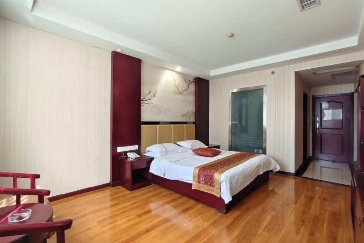 Ein Hotelzimmer mit Bett, Nachttisch und Holzboden.