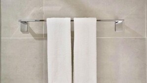 A bathroom with two white towels hanging on a chrome towel rack against a tiled wall. - Homeinn · neo (Shangrao Yushan Tianjie) (Yushan)