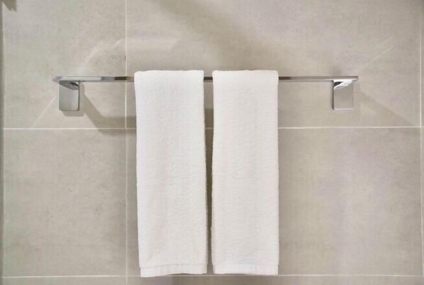 A bathroom with two white towels hanging on a chrome towel rack against a tiled wall. - Homeinn · neo (Shangrao Yushan Tianjie) (Yushan)