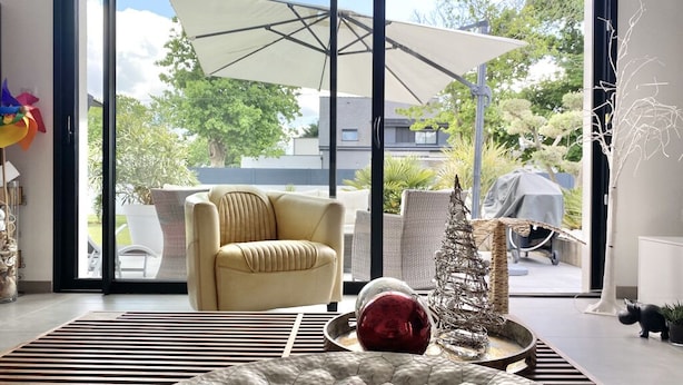A modern living room with a large sliding glass door leading to an outdoor area. - Design Villa with Heated Pool, Garden & Beaches 5 min Away (Concarneau)