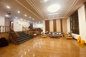 A hotel lobby with a staircase, a reception desk, and a seating area. - Yadu Hotel (Liyang)