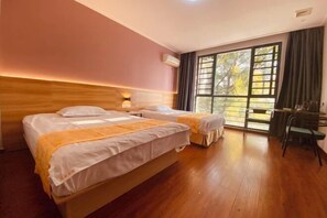 A hotel room with two beds, a desk, and a large window with curtains. - Yadu Hotel (Liyang)