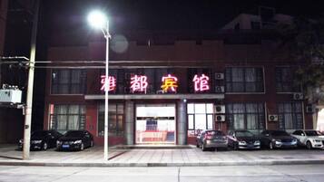 A building with a sign that reads '雅都宾馆' and several parked cars in front.
