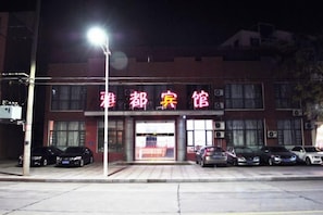A building with a sign that reads '雅都宾馆' and several parked cars in front. - Yadu Hotel (Liyang)
