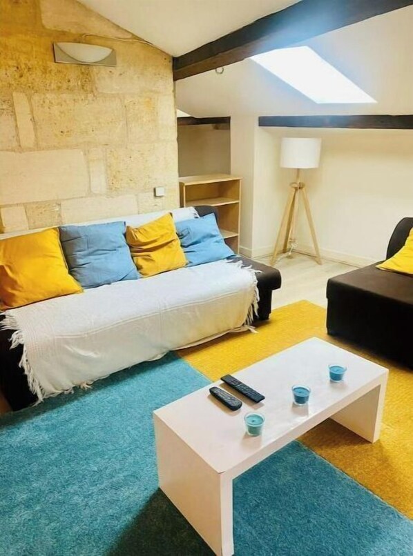A living room with a sofa, a coffee table, and a lamp.