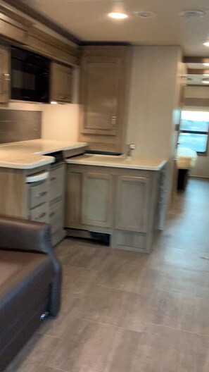 Enjoy cooking in this well-equipped kitchen with a central island, stainless steel range hood, and microwave.