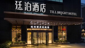 The exterior of Till Bright Hotel with a modern facade, illuminated entrance, and signage in both Chinese and English. - TILL BRIGHT Hotel (Daozhou) (Dao County)