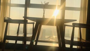 A room with a view through large windows, a table, and two chairs. - TILL BRIGHT Hotel (Daozhou) (Dao County)