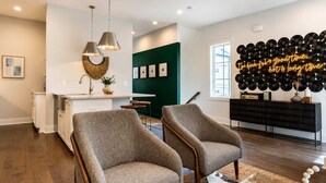 A modern living room with a kitchen area, a dining table, and a wall decorated with vinyl records. - Nashville Escape • Whiskey & Western Vibes (Nashville)