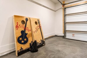Ein Zimmer mit Betonboden, weißer Wand und einer geschlossenen Garagentür.