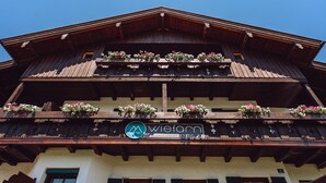A traditional wooden building with multiple balconies adorned with flower boxes. - Spacious apartment with sun terrace in the immediate vicinity of the lake (Bad Wiessee)