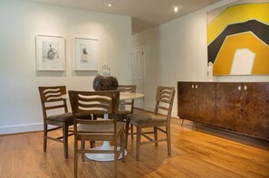 Enjoy meals in this stylish dining area with a round table, four chairs, and a beautiful centerpiece.