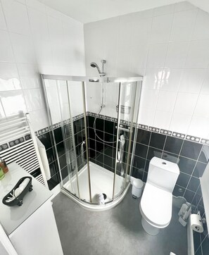 A modern bathroom with a glass-enclosed shower, a toilet, and a sink. - Belle Dene Guest House (Paignton)