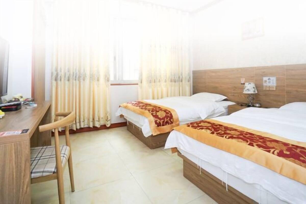 Una habitación de hotel con dos camas, un escritorio y una silla.