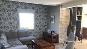 Ein Wohnzimmer mit Sofa, Couchtisch, Bücherregal und Kamin.